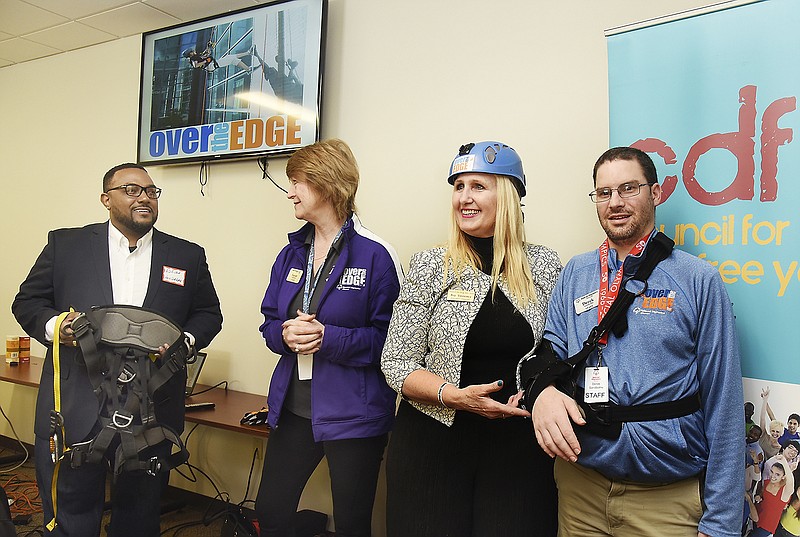 From left, Adrian Hendricks, Council for Drug Free Youth Executive Board vice president, was presented with the official harness from Susan Stegeman, incoming Special Olympics Missouri president, while CDFY Executive Director Joy Sweeney dons the safety helmet presented to her by Training for Life Campus host Derek Sandbothe.