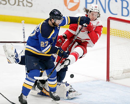 Alex Pietrangelo of the Blues knocks Tyler Bertuzzi of the Red Wings off his feet as a shot goes toward the net during the third period of Thursday night's game in St. Louis.