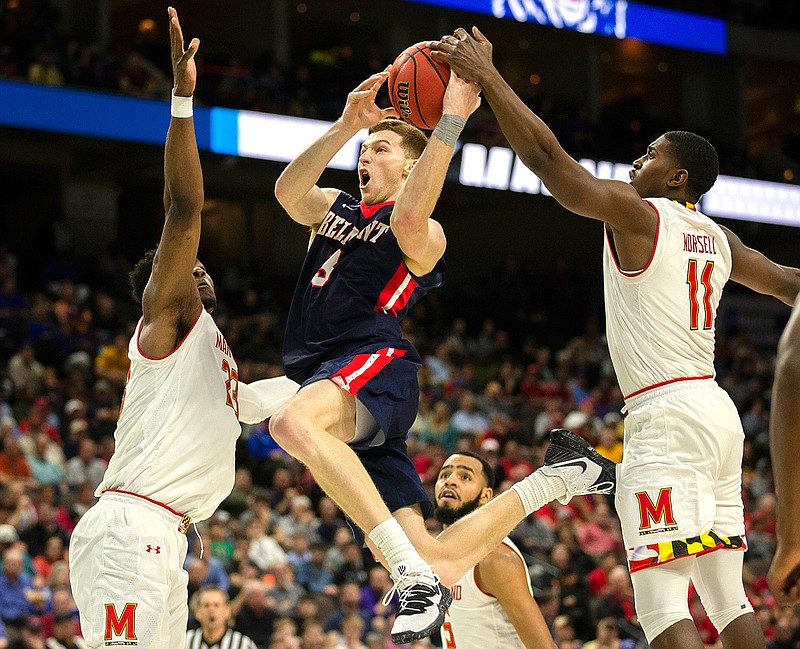 Belmont 's Dylan Windler, center, goes to the basket between Maryland 's Bruno Fernando, left, and Darryl Morsell (11) during the second half of the first round men's college basketball game in the NCAA Tournament in Jacksonville, Fla. Thursday, March 21, 2019. (AP Photo/Stephen B. Morton)