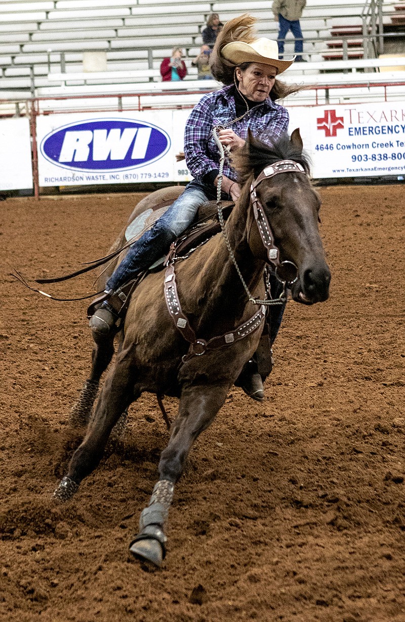 Kelly Courtney from Cave Springs, Ark., rides in to turn her horse, Preaching For Perks, around a barrel at the senior world championship barrel race at Four States Fairgrounds on Thursday in Texarkana, Ark.