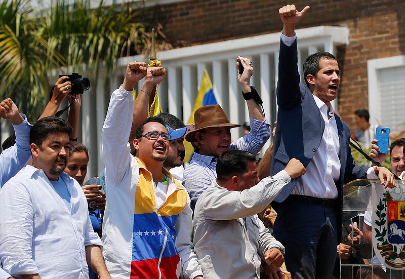In this Saturday, March 16, 2019 photo, lawyer Roberto Marrero, left, attends a rally with Venezuelan opposition leader Juan Guaido, right, who has declared himself interim president in Valencia, Venezuela. Venezuelan security forces detained Marrero, a key aide to Guaido in a raid on his home early Thursday, March 21 an opposition lawmaker said. Marrero was taken by intelligence agents in the overnight operation in Caracas. (AP Photo/Fernando Llano)