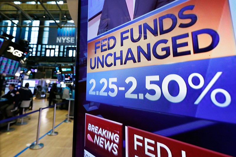 A screen on the floor of the New York Stock Exchange shows the rate decision of the Federal Reserve, Wednesday, March 20, 2019. The Federal Reserve is leaving its key interest rate unchanged and projecting no rate hikes in 2019, dramatically underscoring its plan to be "patient" about any further increases. (AP Photo/Richard Drew)