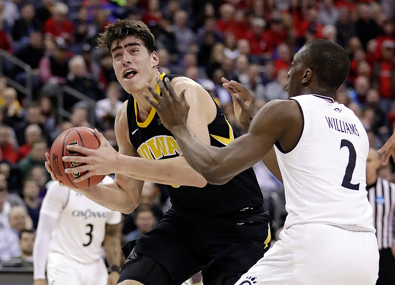Iowa's Luka Garza (55) drives past Cincinnati's Keith Williams (2) in the second half during a first round men's college basketball game in the NCAA Tournament in Columbus, Ohio, Friday, March 22, 2019. (AP Photo/Tony Dejak)