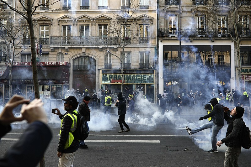 Teargas is used to disperse demonstrators during minor clashes with police in Paris, Saturday, March 23, 2019. The French government vowed to strengthen security as yellow vest protesters stage a 19th round of demonstrations, in an effort to avoid a repeat of last week's riots in Paris. (AP Photo/Kamil Zihnioglu)