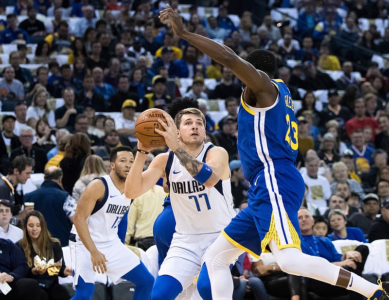 Dallas Mavericks forward Luka Doncic (77) looks to shoot as Golden State Warriors forward Draymond Green defends in the first half of an NBA basketball game Saturday, March 23, 2019, in Oakland, Calif. (AP Photo/John Hefti)