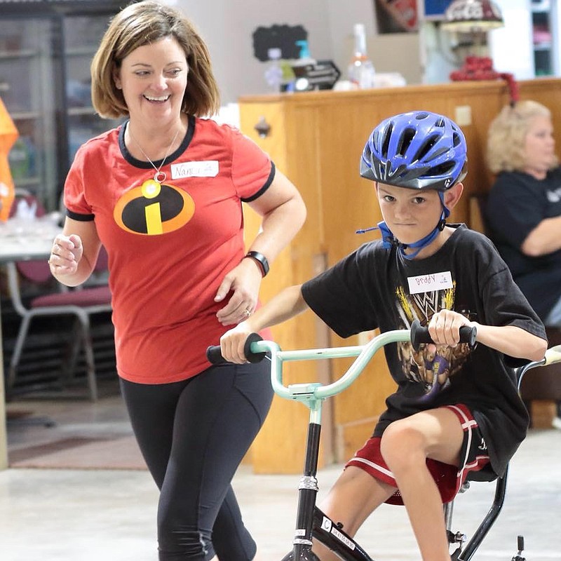 <p>Submitted</p><p>Nancy Hanson helps her friend Brady ride a bike. The Stationary iCan Bike-A-Thon, a family event, will be April 6 to help raise money for the iCan Bike Camp in June.</p>