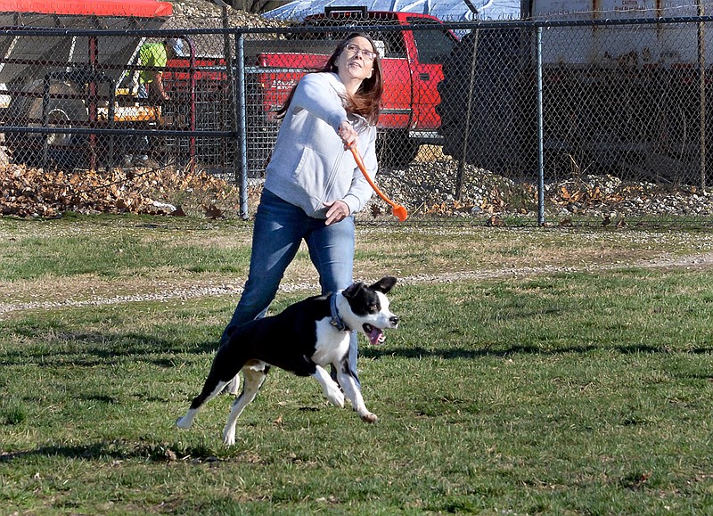 Melissa Johnson and her 2-year-old boxer mix, Ziggy, enjoy a sunny evening Monday March 25, 2019 as they play ball together at the North Jefferson Recreation Area Dog Park. Johnson said she and Ziggy have been coming to the dog park year round since she adopted him for the Jefferson City Animal Shelter in 2017 in order to releive some of his high energy.  The dog park located across the bridge at 810 Sandstone Dr. offers fenced in areas for large and small dogs to stretch their legs and is open seven days a week during normal park hours from 5 a.m.-11 p.m.