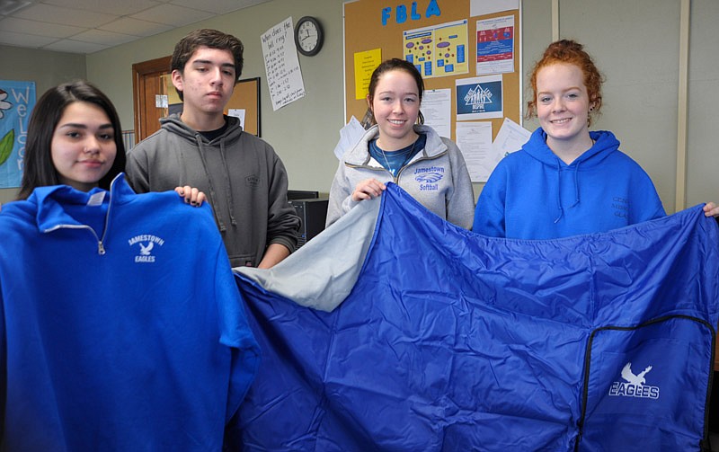 Jasmine Vargas, William Vergas, Kylie Wagner and Shyla Fairsax show off the Eagles Inc sports blanket and quarter-zip sweatshirt. The students are selling the products as part of their business course this semester.