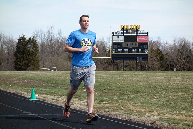 Trevor Neal sails down the Fulton High School track Wednesday, preparing for a 24-hour, 100-mile run starting at 7 p.m. Saturday. He's raising money for suicide prevention and awareness organizations.