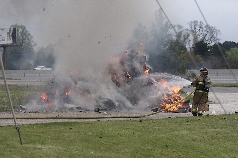 A Texarkana, Ark., firefighter sprays down a pile of trash that caught on fire in the back of a RWI truck on Label Drive.