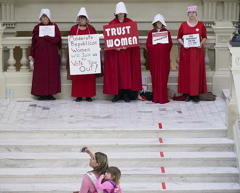 File-This March 22, 2019, file photo shows a woman recording a group of pro-abortion rights demonstrators the 35th legislative day at the Georgia State Capitol building in downtown Atlanta. Bucking intense opposition from abortion rights groups, citizens, physicians groups and even Hollywood celebrities, Georgia lawmakers gave final approval Friday, March 29, 2019, to a "heartbeat" abortion ban that would outlaw almost all abortions in the state. The proposal now heads to the desk of Republican Gov. Brian Kemp, who backs it. If enacted, it would be among the strictest abortion bans in the U.S.(Alyssa Pointer/Atlanta Journal-Constitution via AP, File)