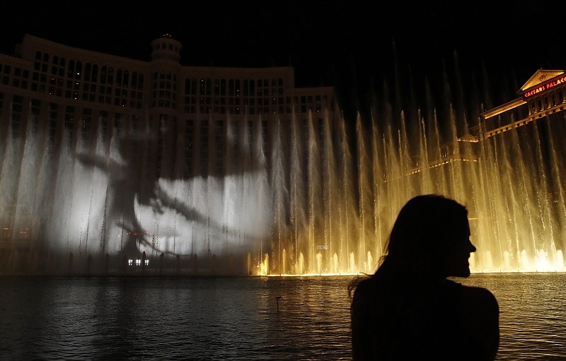 A woman watches during a "Game of Thrones"-themed show at the fountains at the Bellagio casino-resort, Sunday, March 31, 2019, in Las Vegas. (AP Photo/John Locher)
