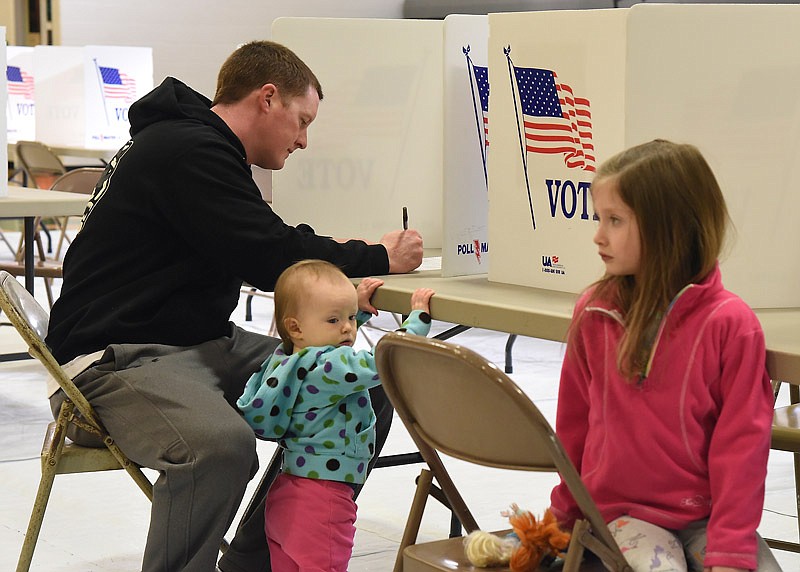 Josh Young brought his daughters Isla, 4, at right, and Emma, 1, to Blair Oaks High School as he cast his ballot in Tuesday's election. Voters from Blair Oaks, Jefferson City and Eugene school districts all vote at this location. Blair Oaks district patrons had a school board seat on the ballot as well as issues to build and operate a new high school. 