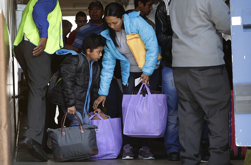 Immigrants from Central America seeking asylum board a bus, Tuesday, April 2, 2019, in downtown San Antonio. The surge of migrants arriving at the southern border has led the Trump administration to dramatically expand a practice it has long mocked as "catch and release." (AP Photo/Eric Gay)