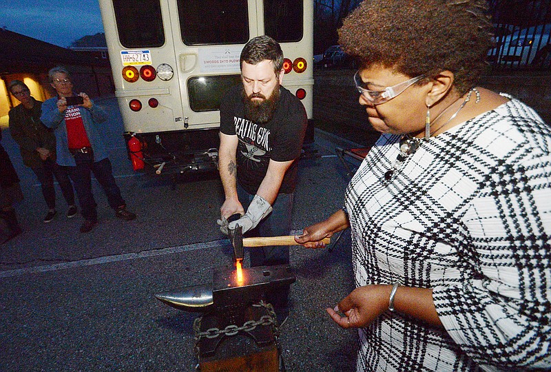 The Rev. Cassandra Gould, Quinn Chapel A.M.E. Church pastor and executive director of Missouri Faith Voices, beats metal from a .22 rifle held by Mike Martin, co-author of the book "Beating Guns: Hope for People Who are Weary of Violence," on Wednesday, April 3, 2019, at the Jefferson City church. "Beating Guns" tour activists gathered for a night of reflection on gun violence and to hammer and pray.