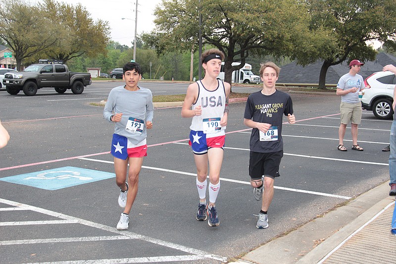 Emiliano Mojia, Brooks Beck and Carson Sanders warm up before Fellowship Bible Church's 6K race. The run served as a fundraiser for an organization that provides clean water to people in developing countries. (Photo by Stan Shavers)
