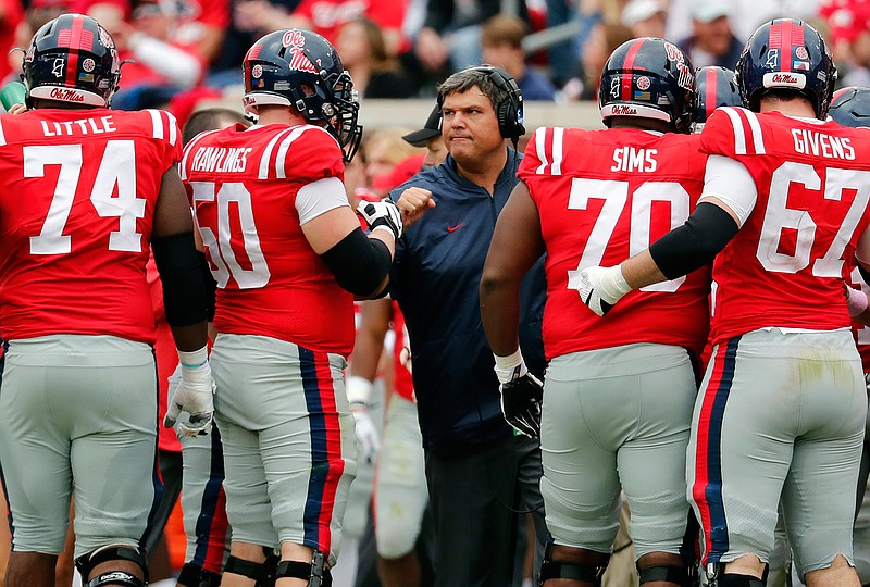 In this Oct. 20, 2018, file photo, Mississippi coach Matt Luke speaks with his players during an NCAA college football game against Auburn in Oxford, Miss. Luke guided Mississippi's football program through the dark days of a two-year NCAA postseason ban. Now the Rebels believe the young coach--along with a few veteran coordinators--can push the program back in the Southeastern Conference's elite. The Rebels have remade their coaching staff over the winter, paying more than $7 million over the next three years to offensive coordinator Rich Rodriguez and defensive coordinator Mike MacIntyre. The well-respected duo has more than two decades of Division I head coaching experience between them. (AP Photo/Rogelio V. Solis, File)