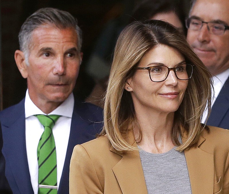 In this April 3, 2019 file photo, actress Lori Loughlin, front, and husband, clothing designer Mossimo Giannulli, left, depart federal court in Boston after facing charges in a nationwide college admissions bribery scandal. On Tuesday, April 9, Loughlin and Giannulli were among 16 prominent parents indicted on an additional charge of money laundering conspiracy in the case. 