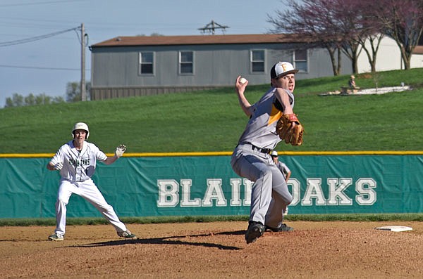 Fulton pitcher Seth Gilbert throws the ball to the plate as David Dell of Blair Oaks takes his lead off second base during Monday's game at the Falcon Athletic Complex in Wardsville.