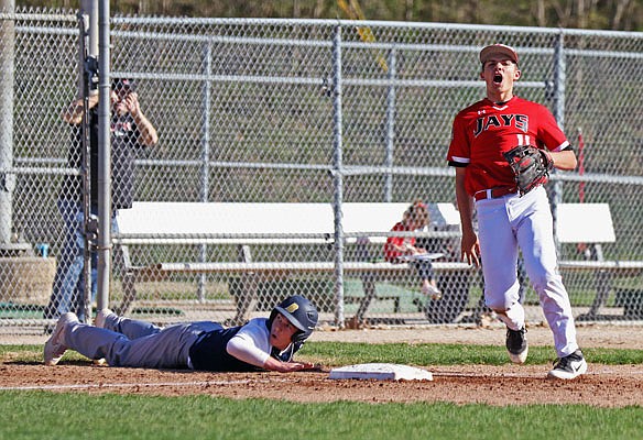 Jefferson City third baseman Dawson Schuemann celebrates after tagging out Battle's Kellen Williamson to complete a double play during the first inning of Tuesday's game at Vivion Field.