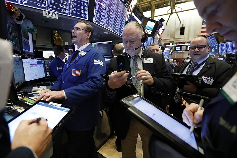 FILE- In this Feb. 12, 2019, file photo specialist Patrick King, left, works with traders at his post on the floor of the New York Stock Exchange. The U.S. stock market opens at 9:30 a.m. EDT on Wednesday, April 10. (AP Photo/Richard Drew, File)