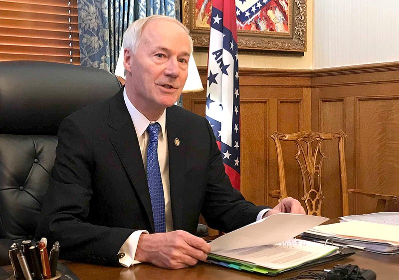 Arkansas Gov. Asa Hutchinson speaks to reporters in his office at the state Capitol in Little Rock, Ark., Wednesday, April 10, 2019, about a bill prohibiting "sanctuary cities" that don't cooperate with federal immigration authorities. The governor said Wednesday he'll sign legislation cutting off funding to "sanctuary cities" that don't cooperate with federal immigration authorities despite the Republican's objections that the measure could open the door to racial profiling. (AP Photo/Andrew DeMillo)