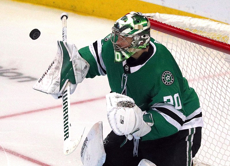 Dallas Stars goaltender Ben Bishop (30) deflects a shot by the Minnesota Wild in the third period of an NHL hockey game Saturday, April 6, 2019, in Dallas. (AP Photo/Richard W. Rodriguez)