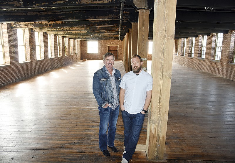 Charlie "MC" Christiansen, left, and his son Charlie, pose in the area of what will be a Big Whiskey's restaurant and bar. It will be located on the east end of the first floor of the former JCD building on E. McCarty Street. The newly renovated area will be known as River Walk and in addition to the restaurant will feature a retail space on the first floor and office space on the third floor. 