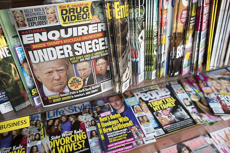 FILE - This July 12, 2017 file photo shows an issue of the National Enquirer featuring President Donald Trump on its cover at a store in New York. The parent company of the National Enquirer said Wednesday, April 10, 2019, that it is exploring the publication's possible sale as part of a "strategic review" of its tabloid business. (AP Photo/Mary Altaffer, File)