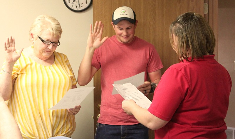<p>Democrat photo/Liz Morales</p><p>Notary Tasha Knapheide swears in Brenda Lapp, District 6, and Mitchell Saunders, District 3, at the April 11 Mid-Mo Ambulance meeting. Saunders was newly elected in Moniteau County; Lapp ran unopposed in Morgan County.</p>