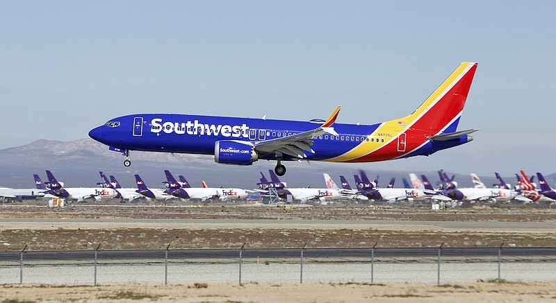 FILE - In this March 23, 2019 file photo a Southwest Airlines Boeing 737 Max aircraft lands at the Southern California Logistics Airport in the high desert town of Victorville, Calif.  Southwest is removing flights with the troubled Boeing 737 Max aircraft from its schedule through Aug. 5, a period that includes the peak of the airline's busy summer travel season. The company did not specify how many flights would be cancelled because of the new schedule. (AP Photo/Matt Hartman, File)