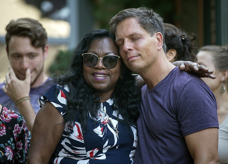 FILE - In this July 20, 2017, file photo, Don Damond, the fiance of Justine Damond, is comforted outside his home by Valerie Castile, the mother of Philando Castile, as demonstrators march by Damond's home in honor of Justine Damond, in Minneapolis. Both Philando Castile and Justine Damond were shot and killed by Minneapolis police officers. The fatal shooting of Justine Damond, an unarmed white woman, by a Somali-American police officer has flipped the racial narrative seen in most police shootings, and some activists say there wouldn’t have been charges if the victim had been black and the officer had been white. (Aaron Lavinsky/Star Tribune via AP, File)