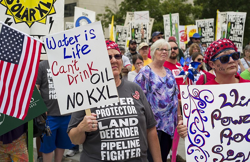 FILE - In this Aug. 6, 2017 file photo, demonstrators against the Keystone XL pipeline listen to speakers in Lincoln, Neb. Eager to jump-start the stalled Keystone XL oil pipeline and other energy projects, President Donald Trump has moved to assert presidential power over pipelines and other infrastructure. (AP Photo/Nati Harnik, File)