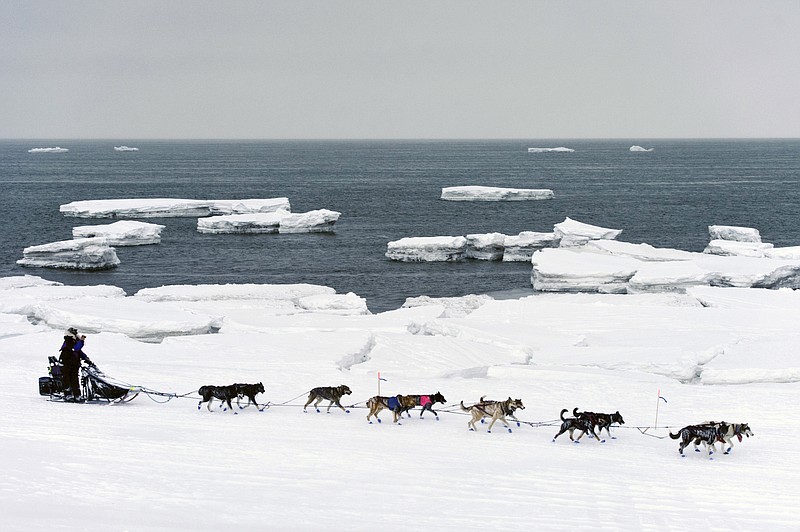 FILE - In this March 13, 2019, file photo, Jessie Royer passes icebergs in open water on Norton Sound as she approaches Nome, Alaska, in the Iditarod trail sled dog race. When a Feb. 22 storm pounded Norton Sound, water surged up the Yukon River and into Kotlik, flooding low-lying homes. The Bering Sea last winter saw record-low sea ice. Climate models predicted less ice, but not this soon, said Seth Danielson, a physical oceanographer at the University of Alaska Fairbanks. (Marc Lester/Anchorage Daily News via AP, File)