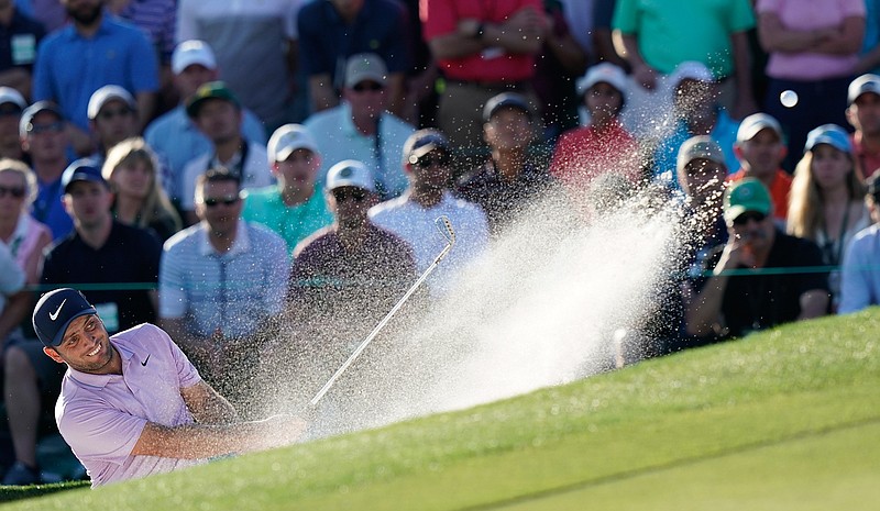 Francesco Molinari, of Italy, hits from a bunker on the 18th hole during the third round for the Masters golf tournament Saturday, April 13, 2019, in Augusta, Ga. (AP Photo/David J. Phillip)