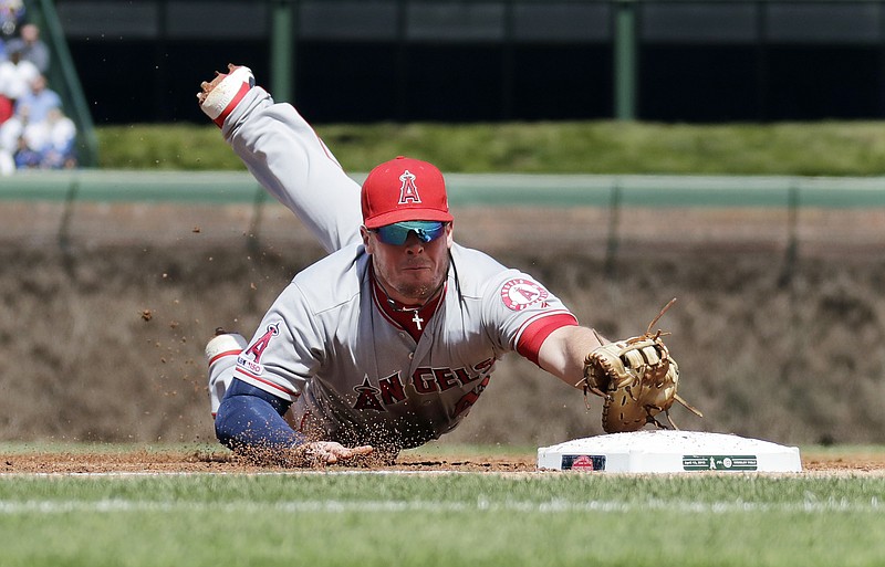 Los Angeles Angels first baseman Justin Bour dives to snag a ground ball hit by Chicago Cubs' Anthony Rizzo during the first inning of a baseball game Saturday, April 13, 2019, in Chicago. Rizzo was out on the play. (AP Photo/Nam Y. Huh)