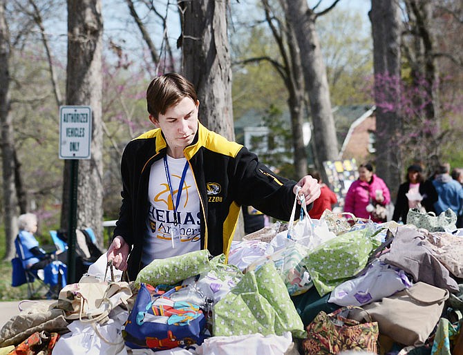 Aaron Sackman, 18, grabs a set of hand-sown gift bags Saturday during the National Crime Victims' Rights Week Resource Fair at Memorial Park. The event featured organizations that address issues of crime prevention, safety and recovery, as well as helping with physical, financial and emotional needs in the community. 