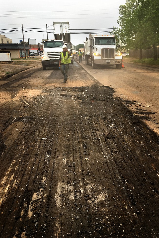 Work on West Seventh Street downtown as seen last week through a fog of dust that a sweeper kicked up in front of the "mill and inlay" process.
