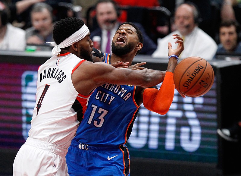 Portland Trail Blazers forward Maurice Harkless, left, knocks the ball away from Oklahoma City Thunder forward Paul George, right, during Game 1 of a first-round NBA playoff series Sunday in Portland, Ore. The Trail Blazers won, 104-99.