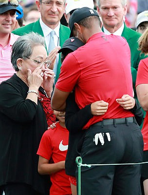Tiger Woods' mother, Kultida Woods, wipes away tears Sunday as he hugs his daughter, Sam, and son, Charlie, after winning the Masters in Augusta, Ga.