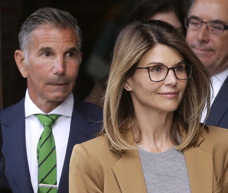 FILE - In this April 3, 2019 file photo, actress Lori Loughlin, front, and husband, clothing designer Mossimo Giannulli, left, depart federal court in Boston after facing charges in a nationwide college admissions bribery scandal. Loughlin and her husband Giannulli said in court documents Monday, April 15, 2019, that they are pleading not guilty to charges that they took part in a sweeping college admissions bribery scam.  (AP Photo/Steven Senne, File)