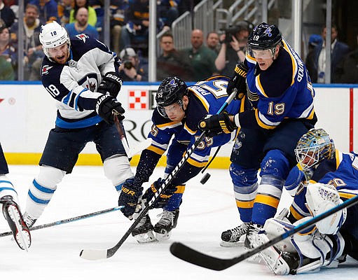 Bryan Little of shoots against the defense of Blues teammates (from left) Colton Parayko, Jay Bouwmeester and goaltender Jordan Binnington during the first period of Sunday night's Game 3 of their NHL first-round playoff series in St. Louis.