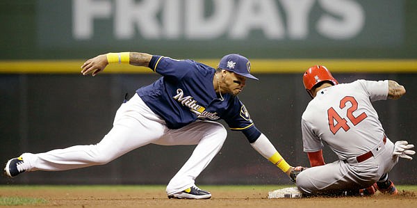 Kolten Wong of the Cardinals slides in ahead of the tag by Orlando Arcia of the Brewers during the fourth inning of Monday night's game in Milwaukee.