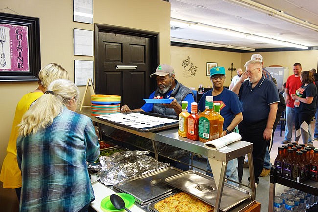 Volunteers serve up their first meal at the new Fulton Soup Kitchen location on Fourth Street in April. The soup kitchen is one of many places offering free food to whoever needs it during the summer.
