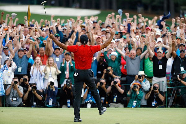 Tiger Woods celebrates after sinking his final putt Sunday to win the Masters at Augusta National Golf Club in Augusta, Ga.