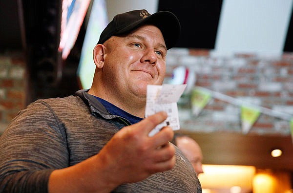 James Adducci holds his winning ticket Monday in Las Vegas after winning more than $1.2 million betting on Tiger Woods to win the Masters.