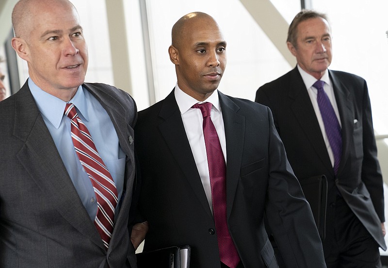 FILE--In this April 1, 2019, file photo, former Minneapolis police officer Mohamed Noor, center, leaves the Hennepin County Government Center after the first day of jury selection with his attorneys Thomas Plunkett, left, and Peter Wold, in Minneapolis, Minn. Testimony in Noor's trial has shined a light on officers' actions at the scene and raised questions about whether they were trying to protect one of their own. The incident commander turned her body camera off when talking to Noor in the moments after the July 2017 shooting of Justine Ruszczyk Damond, while other officers who responded told him not to say a word, according to prosecutors and court testimony. (Renee Jones Schneider/Star Tribune via AP, File)