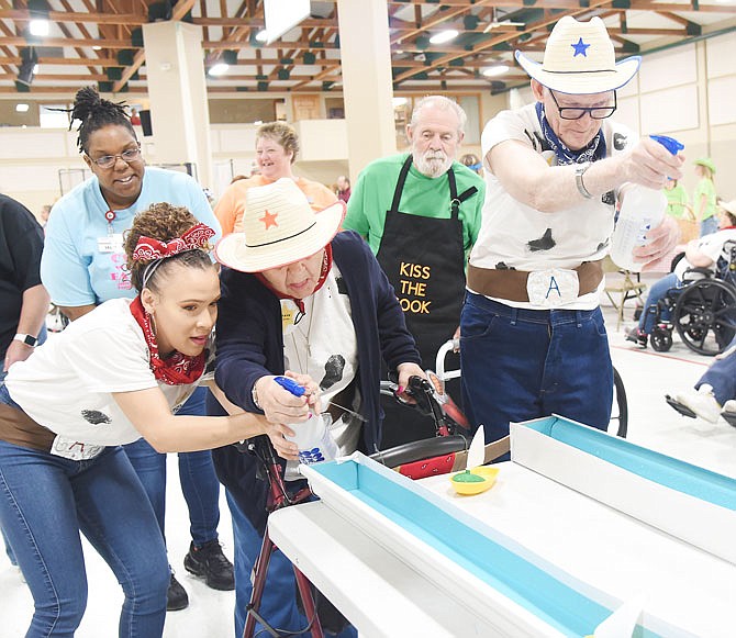 Stephany Hinton, left, assists Lillie Roark as she and Russell Coleman, at right, participate Tuesday in a boat race during the annual Missouri Health Care Association's District 7 2019 Golden Age Games at Capital West Christian Church Event Center. Roark and Coleman are residents at Adams Street Place — one of eight area nursing homes — and participated in the day's events.