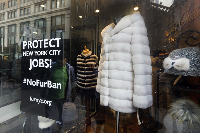 This April 10, 2019, photo shows a sign by furnyc.org in the window of Victoria Stass Collection in New York's fur district. The fur trade is considered so important to New York’s development that two beavers adorn the city’s official seal, a reference to early Dutch and English settlers who traded in beaver pelts. (AP Photo/Richard Drew)