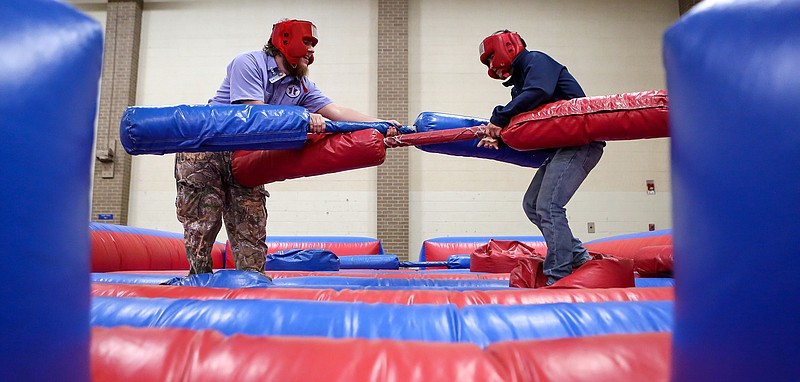 Jarrod Wade and Jose Bustamante spar with double-sided battle sticks Thursday at the Texarkana College Spring Fling event in Texarkana, Texas. The event had food, clubs for students to join and fun activities.